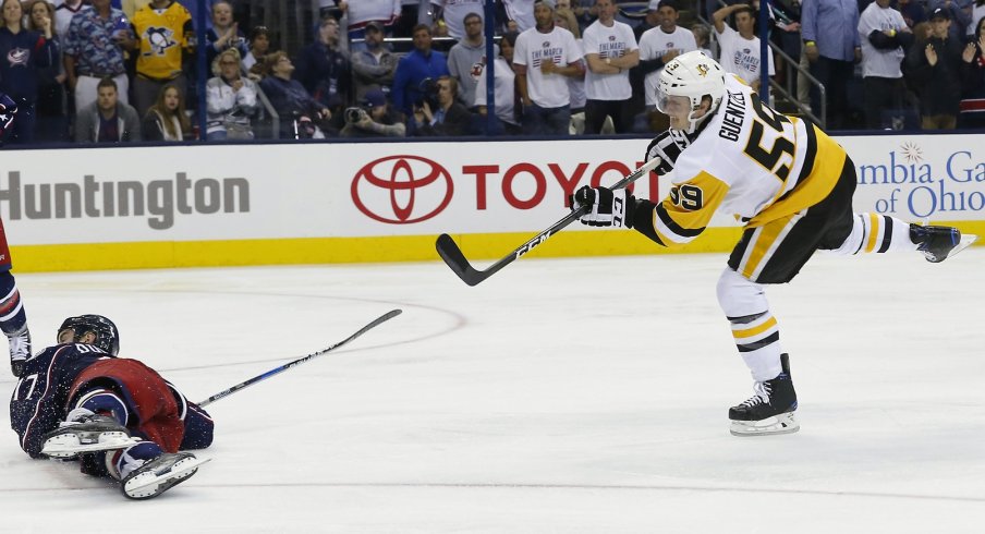 Jake Guentzel shoots the puck over Brandon Dubinsky in overtime