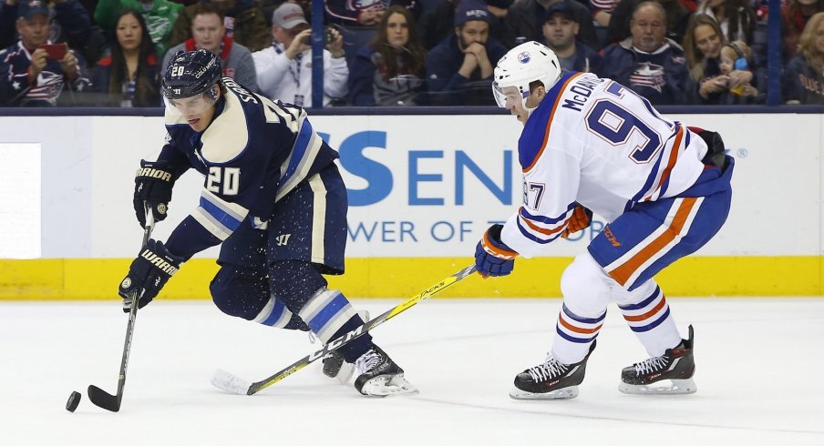 Oilers' forward Connor McDavid works hard to track down Blue Jackets' forward Brandon Saad