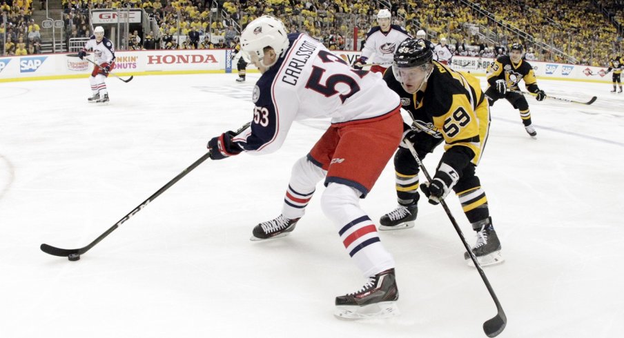 Gabriel Carlsson skates away from Penguins' forwards.