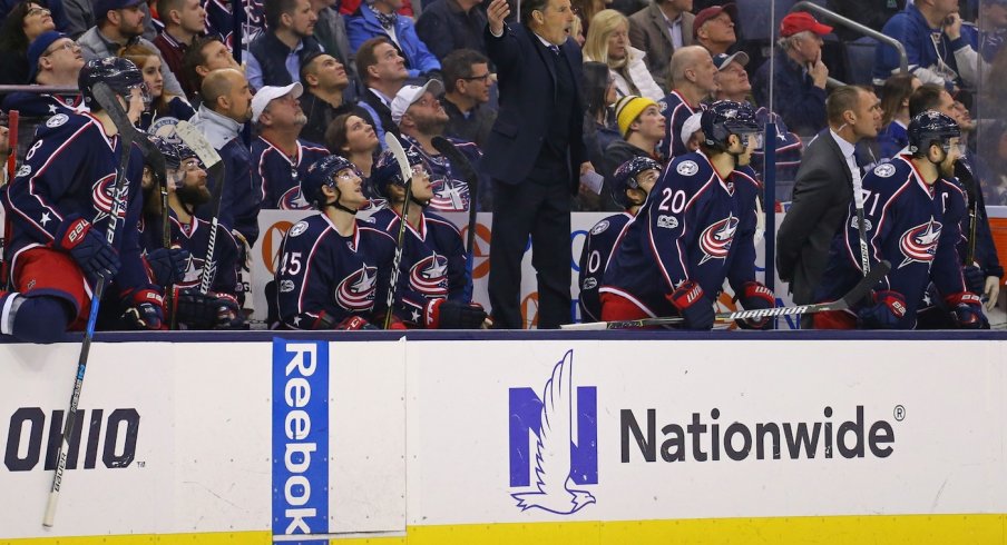 John Tortorella tries to get the referee's attention on the bench