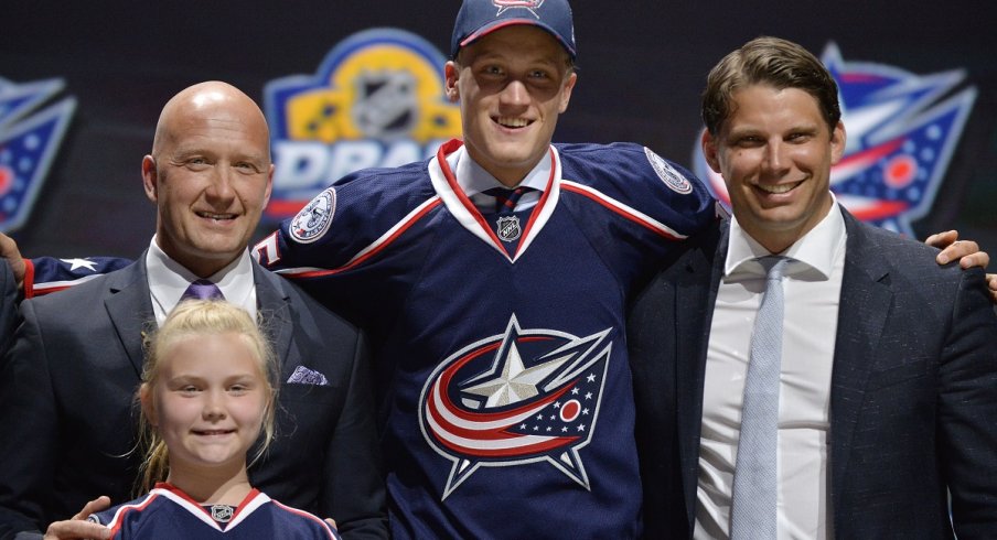 Gabriel Carlsson poses with team officials after being selected 29th overall in the 2015 NHL Draft.