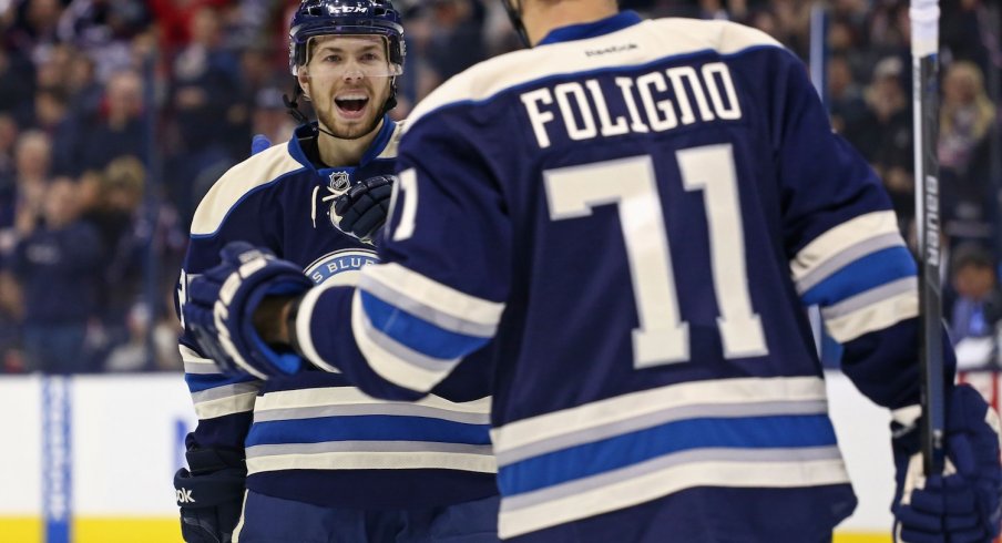 Oliver Bjorkstrand and Nick Foligno celebrate after scoring a goal.