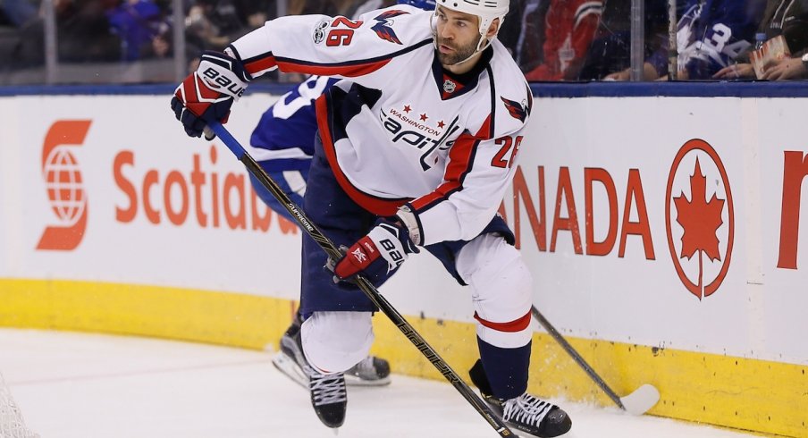 Daniel Winnik attempts to carry the puck out of the zone against the Toronto Maple Leafs