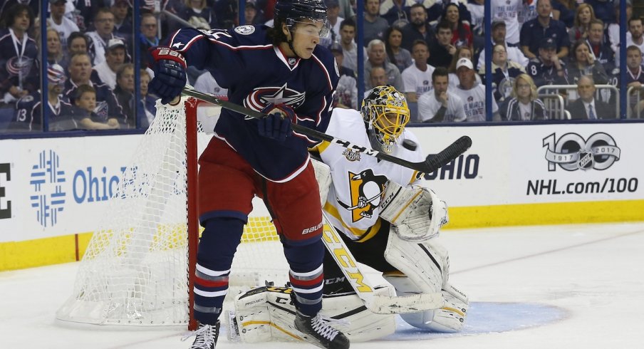 Sonny Milano sits in front of the Penguins net as he tries to deflect the puck