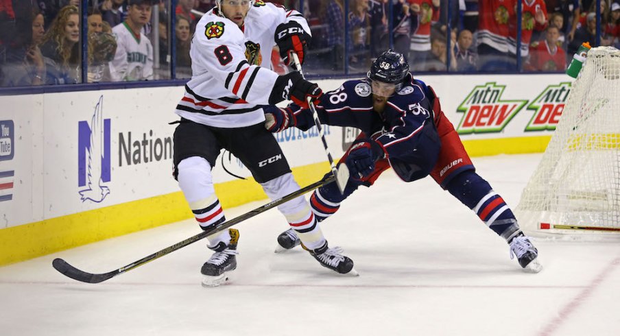 David Savard of the Blue Jackets defends against Nick Schmaltz of the Blackhawks