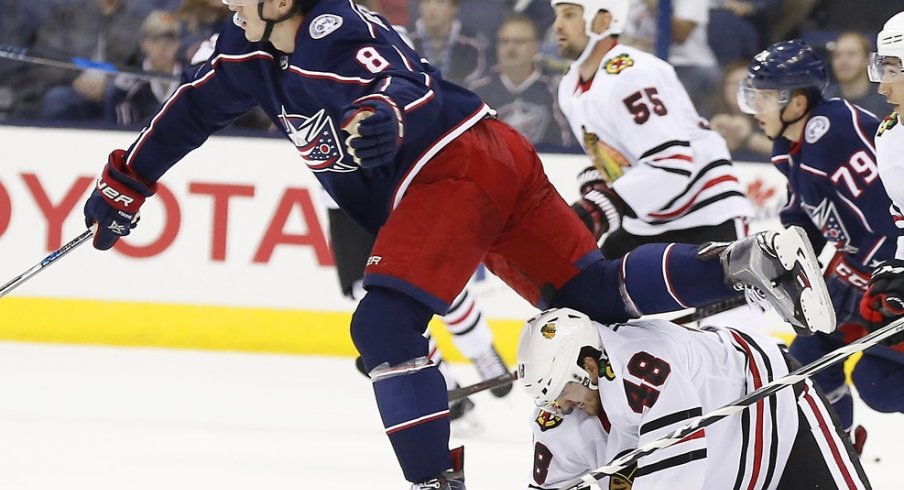 Zach Werenski tries to avoid Blackhawk players during a preseason game