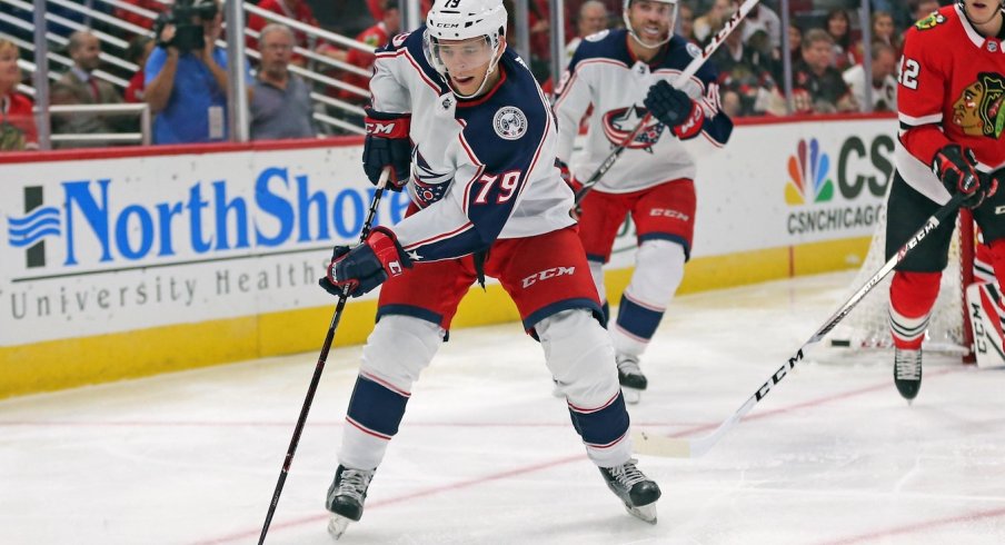 Vitaly Abramov skates away from defenders as he handles the puck