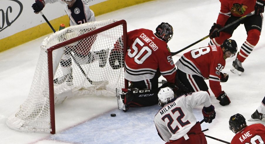 Sonny Milano eyes the puck before he pushes it across the line for a goal against the Chicago Blackhawks