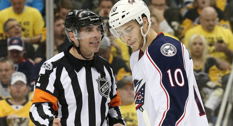 A referee yells at Alexander Wennberg during a preseason game in Pittsburgh