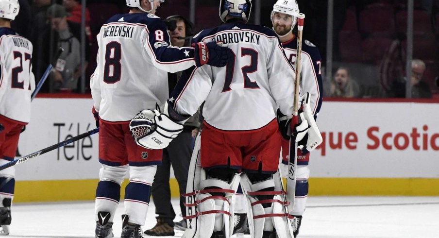 Sergei Bobrovsky meets with Zach Werenski and Nick Foligno at center ice after a victory