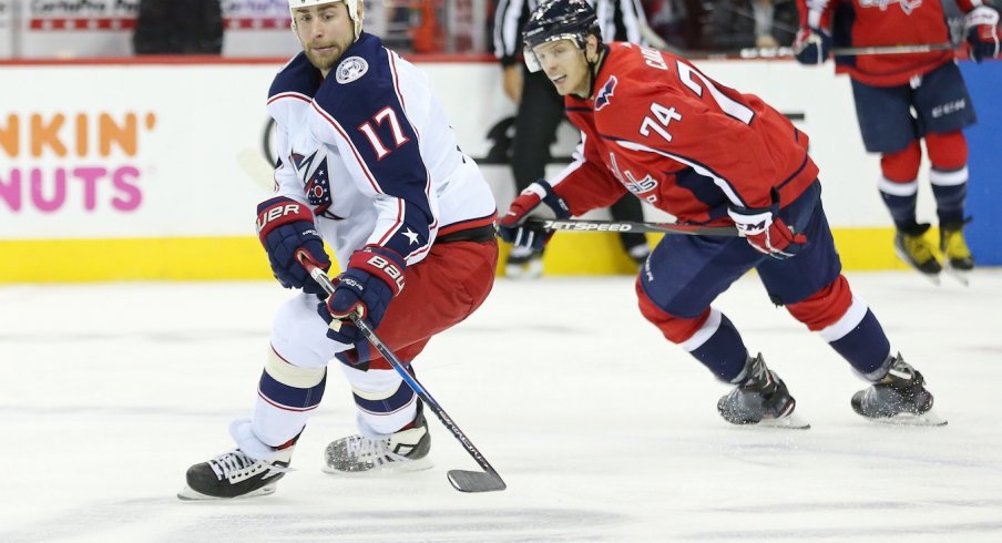 Brandon Dubinsky skates up the ice as John Carlson works to take away the puck