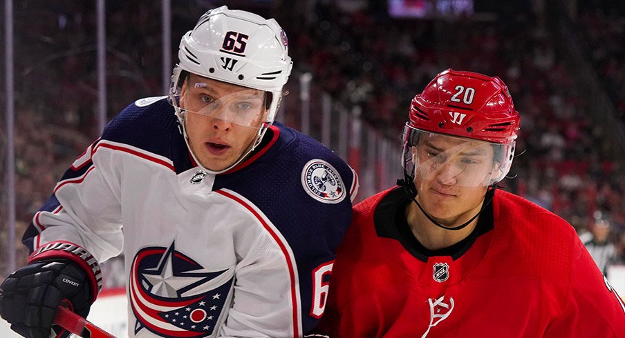 Markus Nutivaara and Sebastian Aho battle for a puck in Carolina.