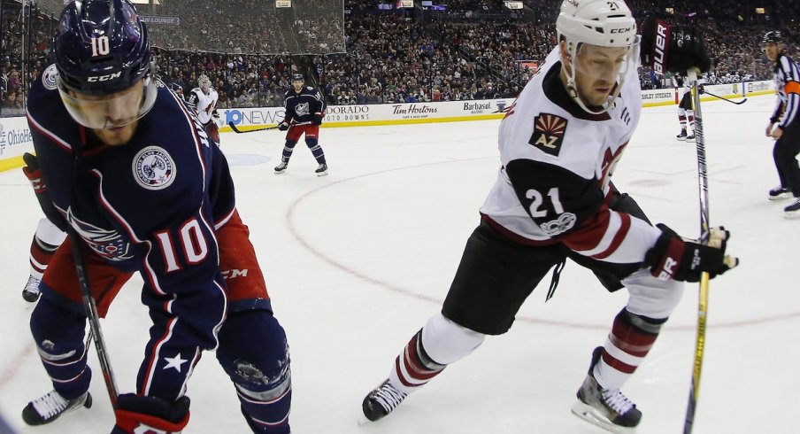 Alexander Wennberg fights for the puck along the wall against Derek Stepan