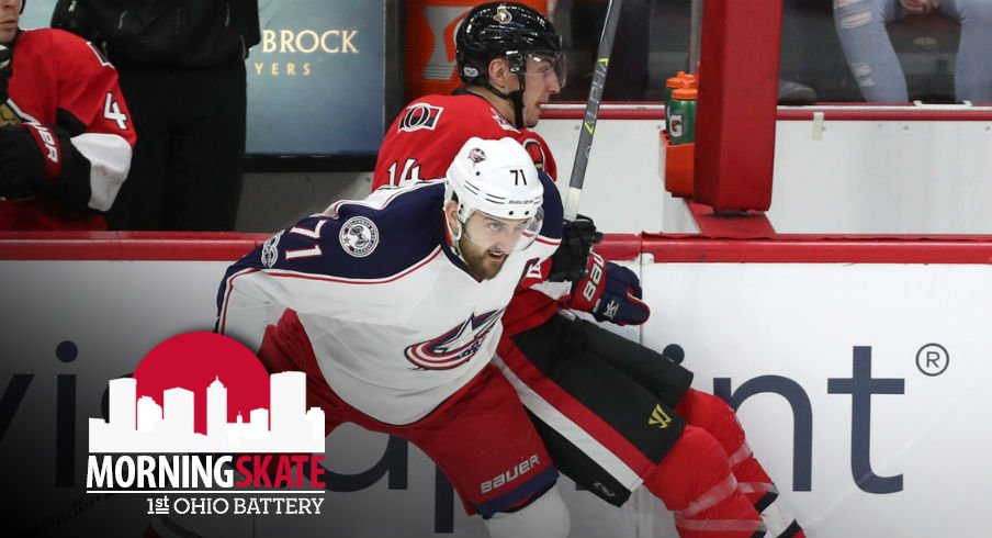 Nick Foligno fights for the puck on the boards against Alexandre Burrows 