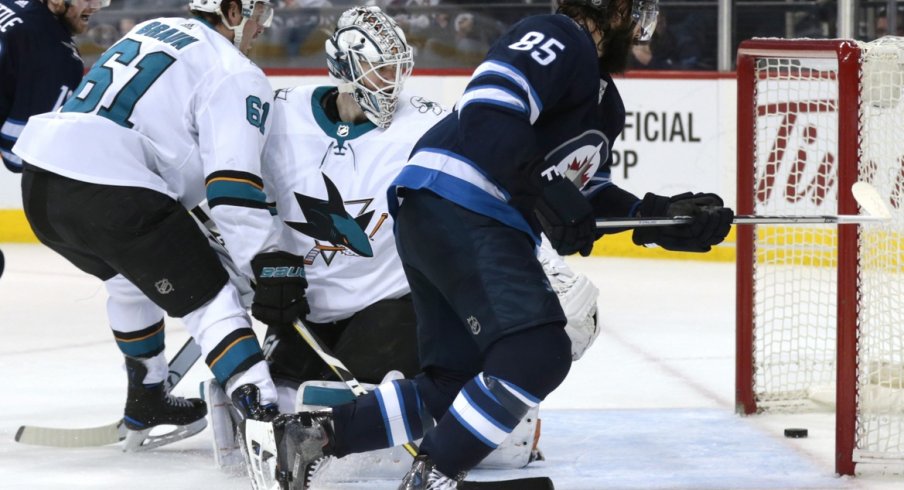 Jets forward Mathieu Perrault slips a puck past Sharks goaltender Martin Jones