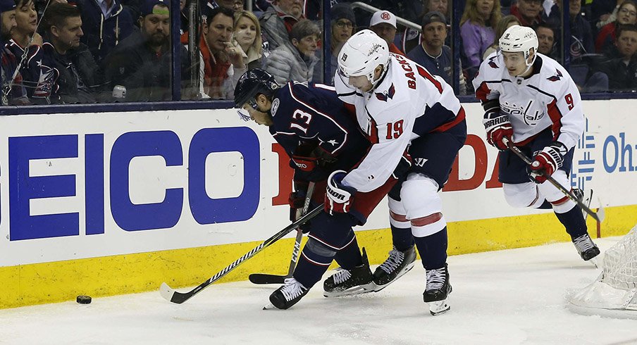 Cam Atkinson and Nicklas Backstrom battle on the boards.