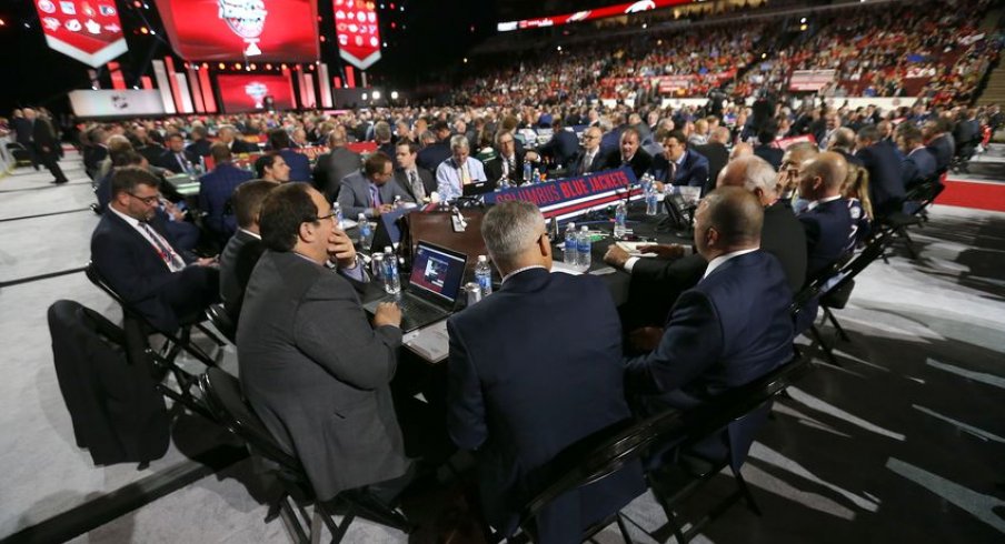 Jarmo Kekalainen, John Davidsson and Blue Jackets scouts discuss things at their draft table