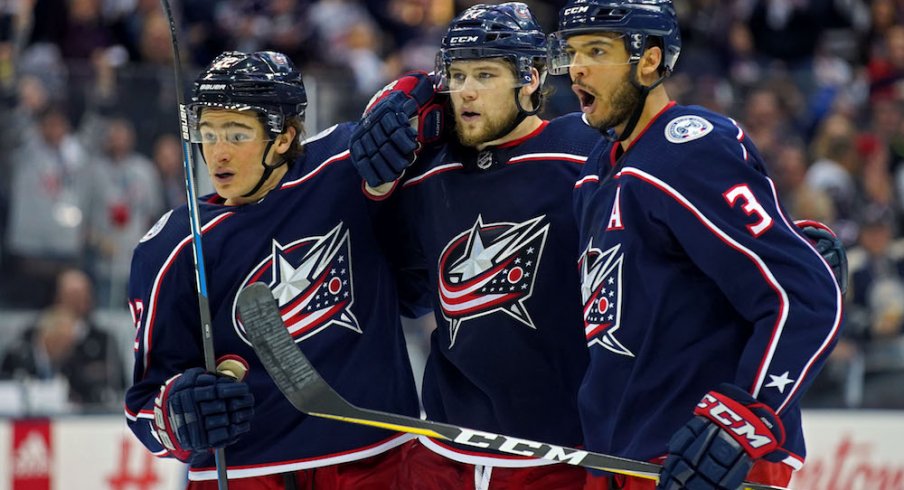 Seth Jones, Josh Anderson and Sonny Milano celebrate a Blue Jackets goal against the Washington Capitals.