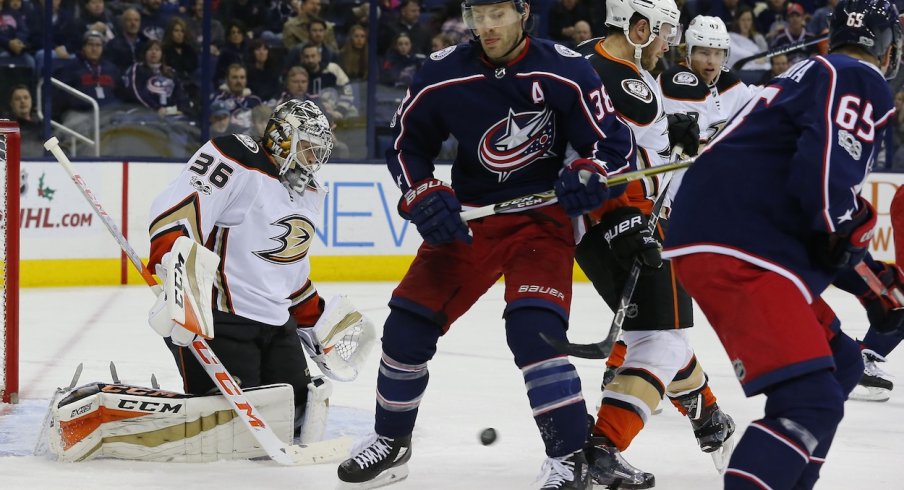 Anaheim Ducks goaltender John Gibson attempts to stop a puck against the Columbus Blue Jackets