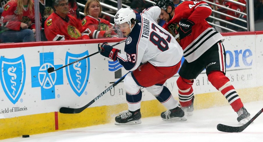 Blue Jackets prospect Calvin Thurkauf battles for a loose puck during preseason action against the Chicago Blackhawks.