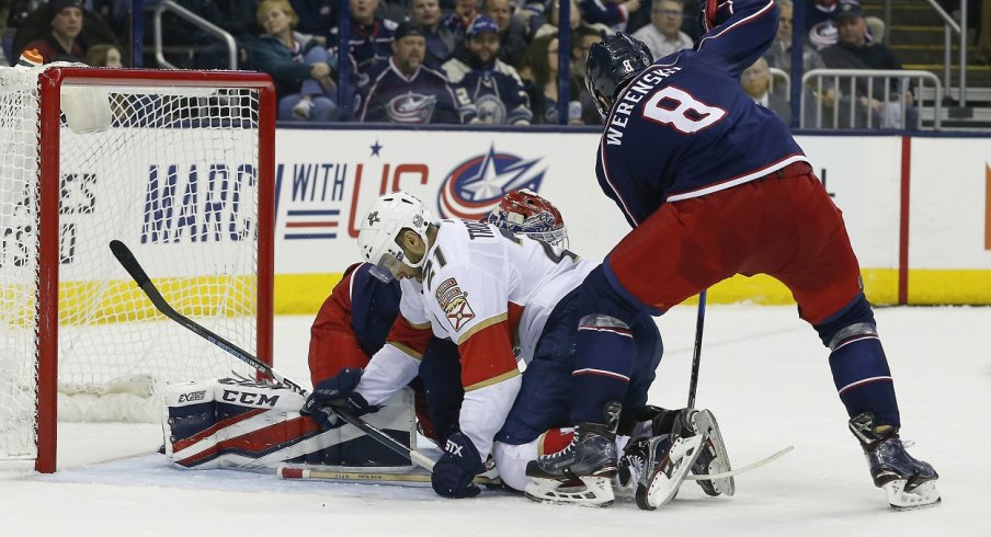 Zach Werenski tries to clear the puck against the Florida Panthers