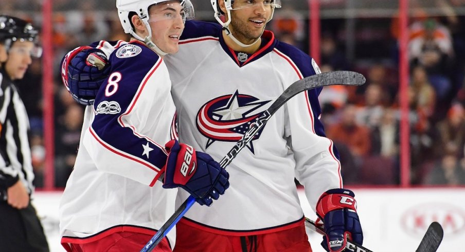 Zach Werenski and Seth Jones celebrate after scoring a goal against the Philadelphia Flyers.