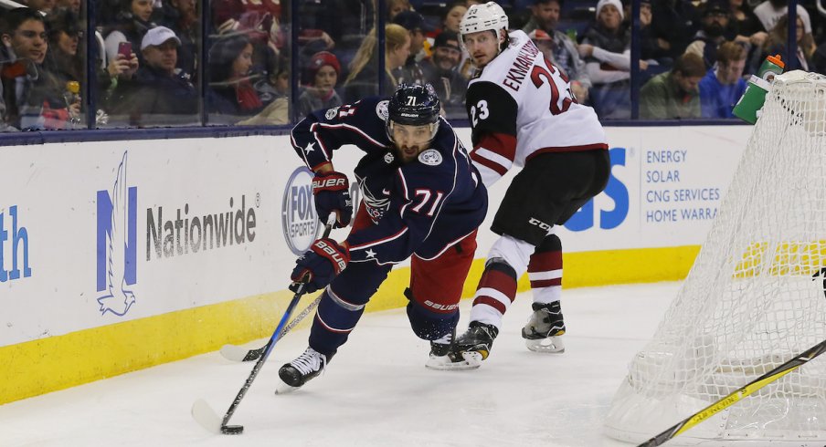 Columbus Blue Jackets captain Nick Foligno protects the puck against Arizona Coyotes defenseman Oliver Ekman-Larsson during a game at Nationwide Arena.
