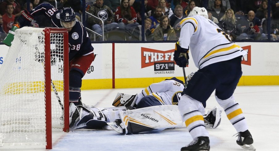 Forward Boone Jenner tries to sneak the puck past goaltender Linus Ullmark