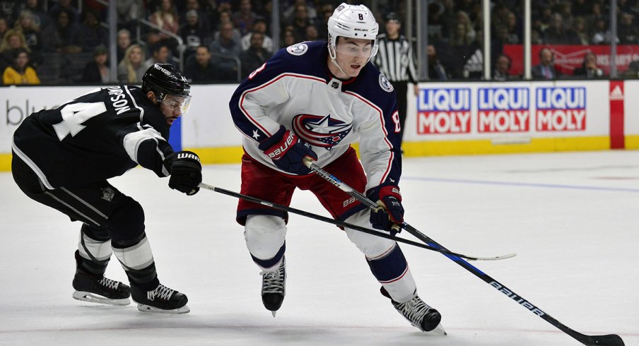 Zach Werenski skates with the puck against the Los Angeles Kings 