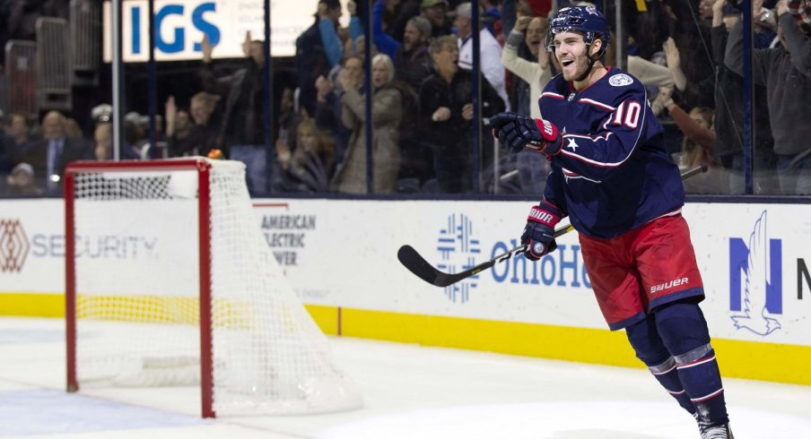 Alexander Wennberg celebrates his first goal of the season by pointing at Seth Jones, who set him up.