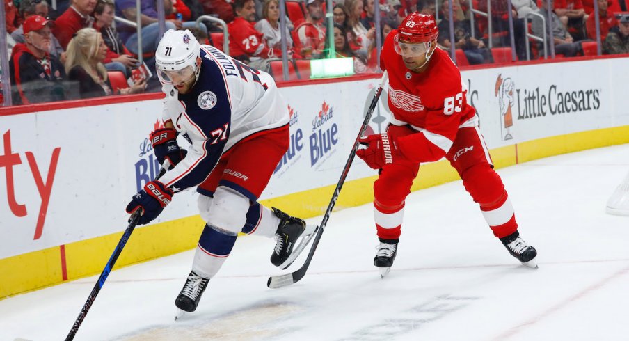 Columbus Blue Jackets captain Nick Foligno protects the puck away from Detroit Red Wings defenseman Trevor Daley during a game at Little Caesars Arena.