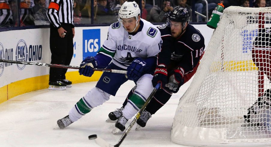 Jake Virtanen carries the puck against Pierre-Luc Dubois in the Vancouver Canucks beat the Columbus Blue Jackets 3-2