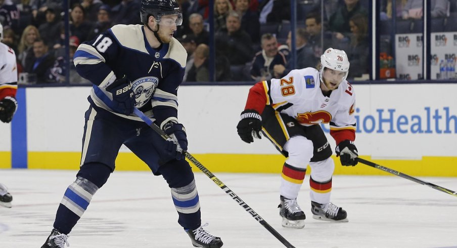 Pierre-Luc Dubois looks to move the puck in The Blue Jackets 9-6 loss to the Calgary Flames