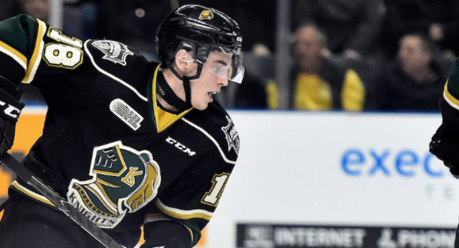 Liam Foudy reaches for the puck and tries to skate up ice