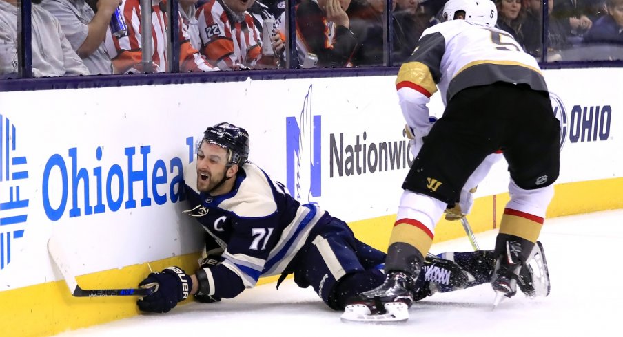 Nick Foligno goes head first into the boards after being checked by the Vegas Golden Knights' Derek Engelland.