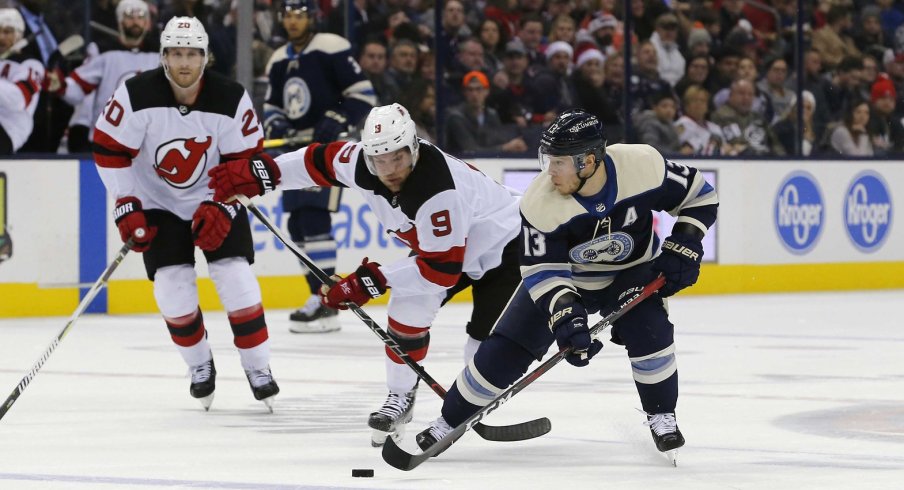 Cam Atkinson skates against Taylor Hall as the Columbus Blue Jackets take on the New Jersey Devils