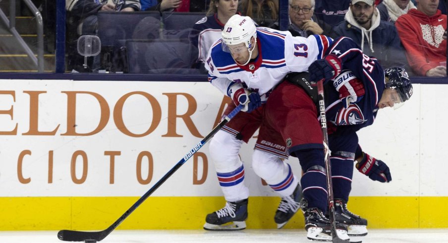 Blue Jackets Markus Nutivaara hits New York Rangers Kevin Hayes into the boards as he tries to get by with the puck