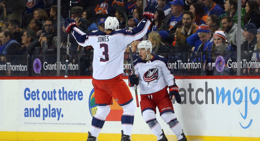 Seth Jones celebrates with Cam Atkinson after the latter scores a goal.