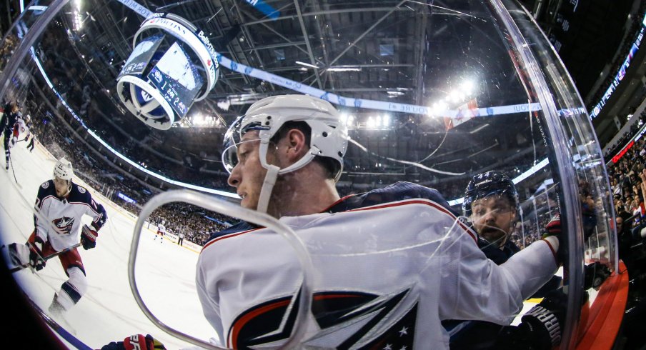 Pierre-Luc Dubois looks on as Artemi Panarin plays the puck