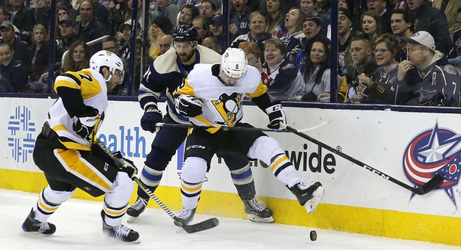 Chad Ruhwedel kicks the loose puck away from Nick Foligno at Nationwide Arena