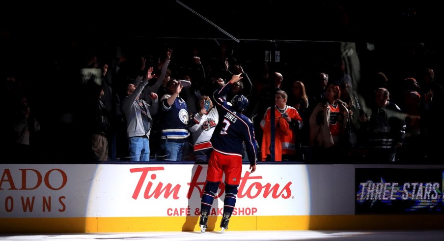 Seth Jones gives a fan a stick after the Blue Jackets overtime win