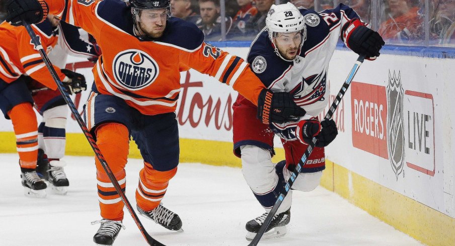 Edmonton Oilers forward Leon Draisaitl (29) and Columbus Blue Jackets forward Oliver Bjorkstrand (28) battle for a loose puck during the second period at Rogers Place.