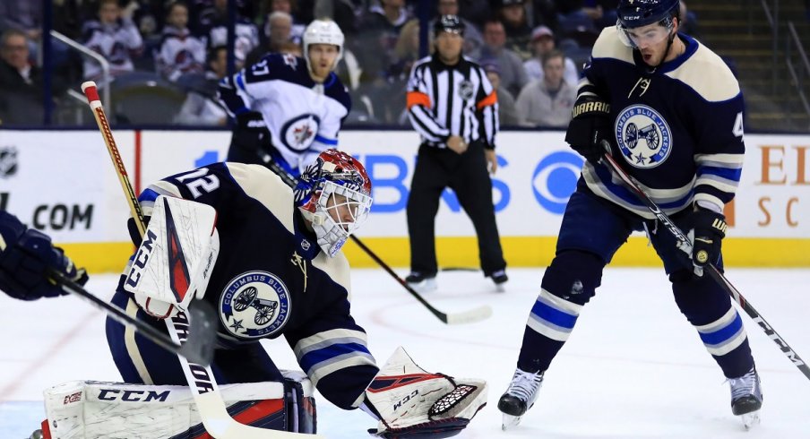 Sergei Bobrovsky attempts to make the save as Scott Harrington reacts against the Winnipeg Jets in the first period at Nationwide Arena.