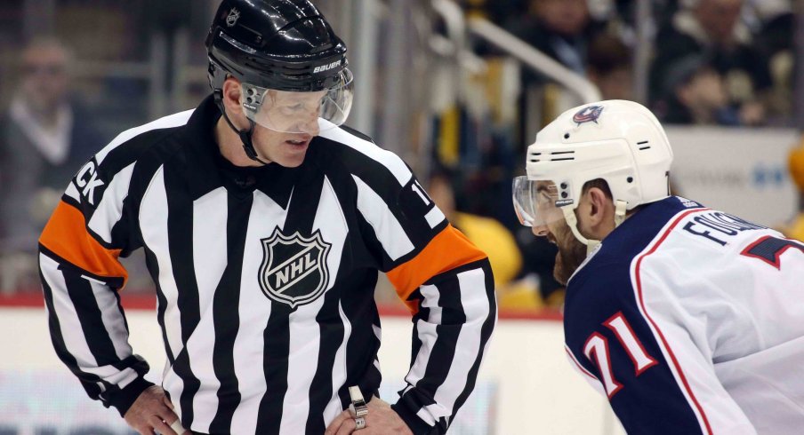 NHL referee Kelly Sutherland (11) talks with Columbus Blue Jackets left wing Nick Foligno (71) against the Pittsburgh Penguins during the third period at PPG PAINTS Arena. The Penguins shutout the Blue Jackets 3-0.