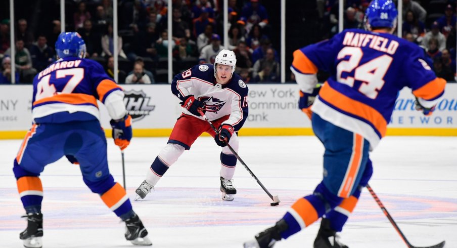 Columbus Blue Jackets center Ryan Dzingel (19) skates with the puck while being defended by New York Islanders right wing Leo Komarov (47) and defenseman Scott Mayfield (24) during the first period at Nassau Veterans Memorial Coliseum.