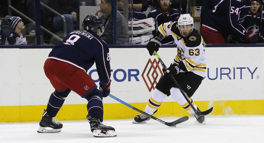 Zach Werenski takes the puck away from Brad Marchand in a victory over the Boston Bruins on Tuesday night.