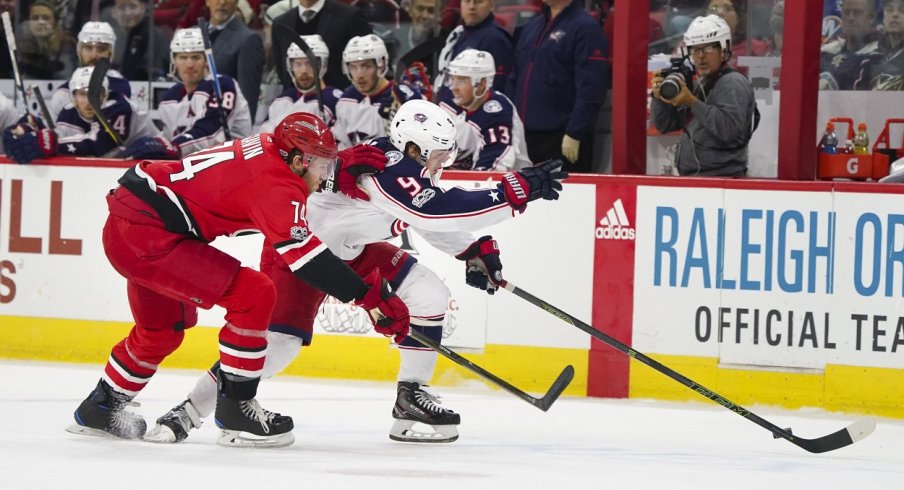 Artemi Panarin attempts to skate by Hurricanes defenseman Jaccob Slavin