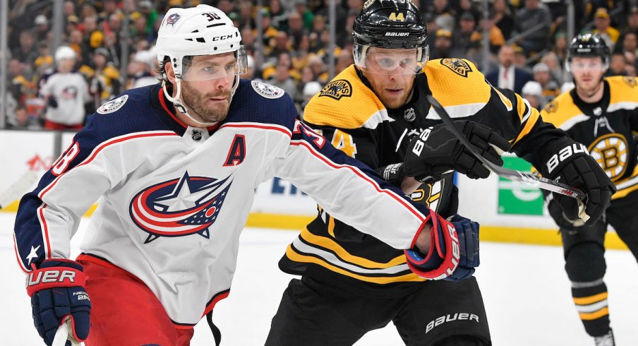 Columbus Blue Jackets center Boone Jenner fights for the puck against the Boston Bruins during a game at TD Garden.