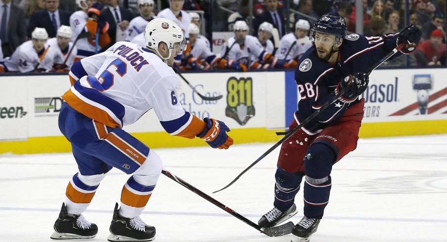 Oliver Bjorkstrand chips the puck past defenseman Ryan Pulock of the New York Islanders