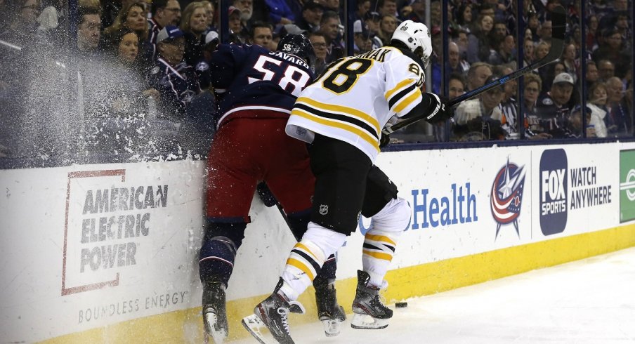 Boston Bruins right wing David Pastrnak (88) checks Columbus Blue Jackets defenseman David Savard (58) during the first period at Nationwide Arena.